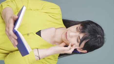 Vertical-video-of-Woman-with-notebook-thinks-and-takes-notes.